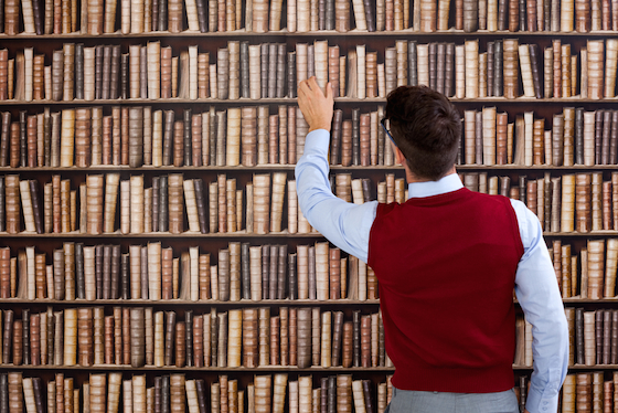 Image of man choosing book from a library